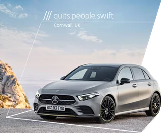 A silver Mercedes-Benz parked with a scenic backdrop in Cornwall, UK.