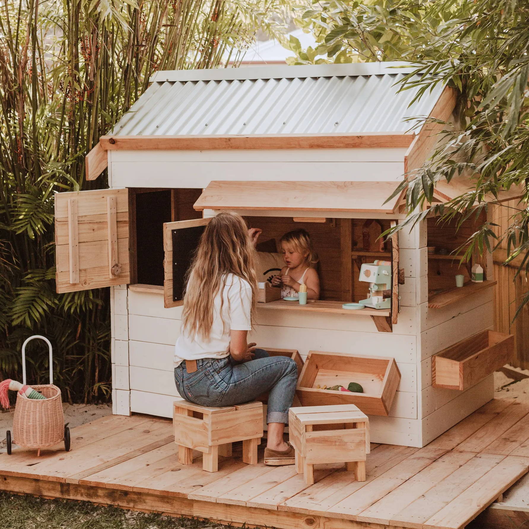 A pithced roof style cubby house with a mom and a kid