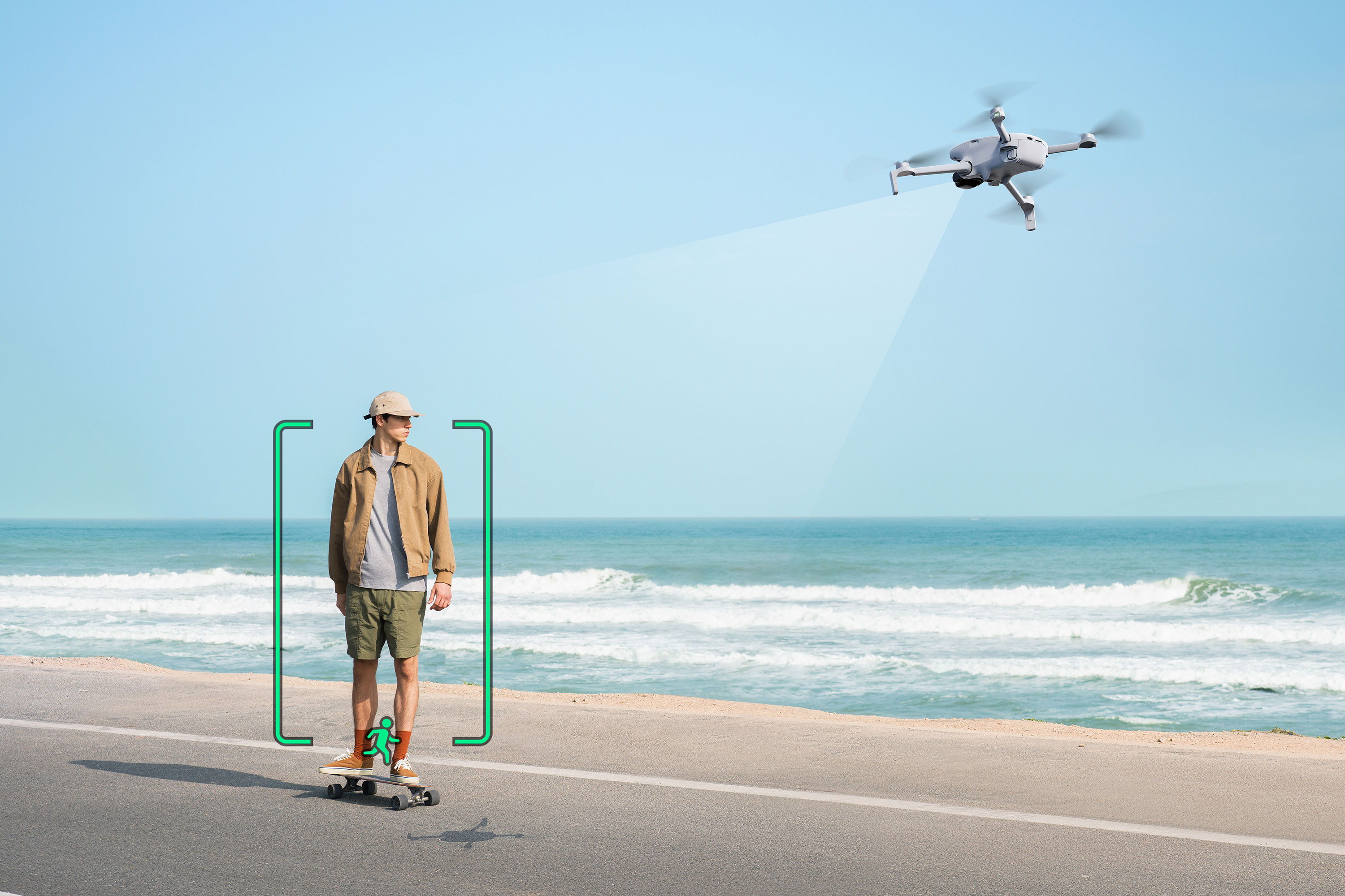 Person skateboarding on a beach road with a DJI Lito X1 flying overhead, an icon over the person showcases the tracking feature