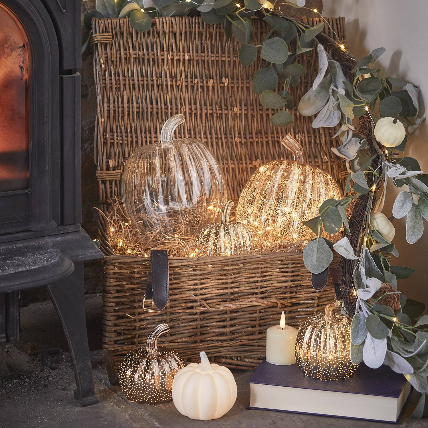  A wicker basket with a green autumn garland and 5 pumpkin lights nestled inside.