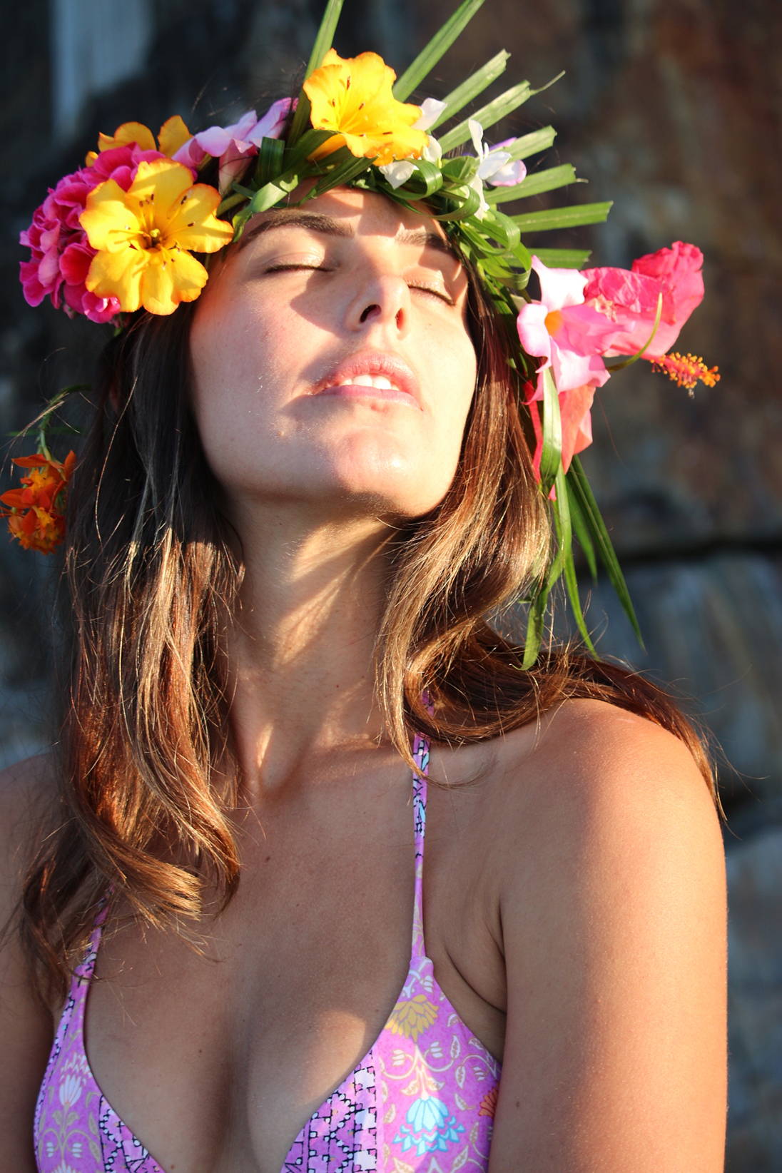 Solo female sailor wears Tigerlily pink boho bikini top with flowers in her hair