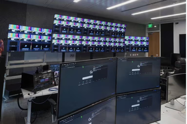 A control room with multiple screens displaying various information.