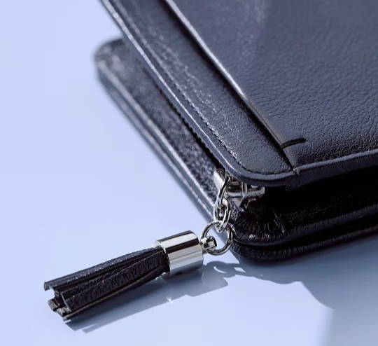 Black wallet with a zipper and a tassel charm.