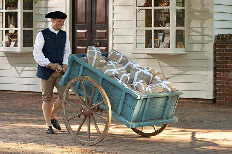 Man pushing cart with packages inside.