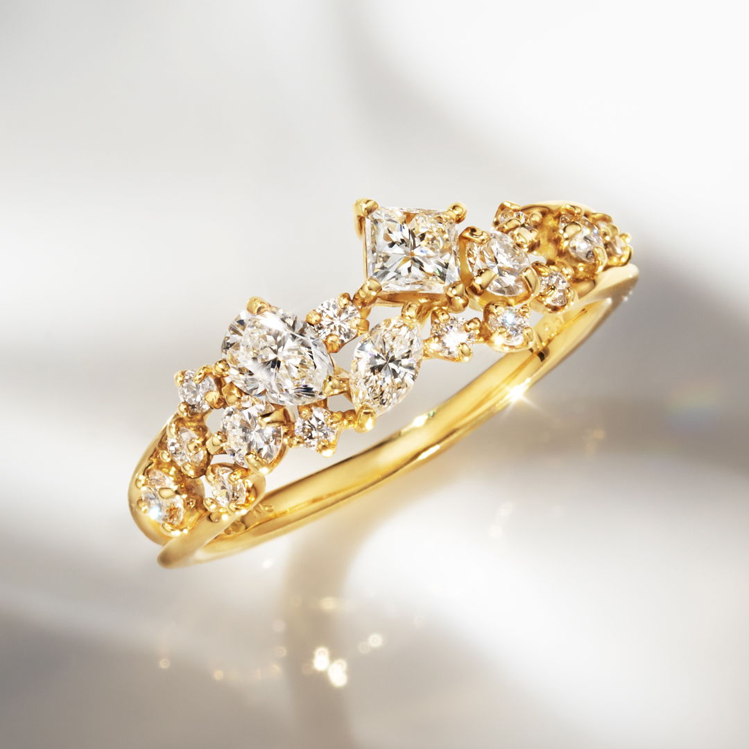 Gold ring adorned with sparkling diamonds on a reflective surface.