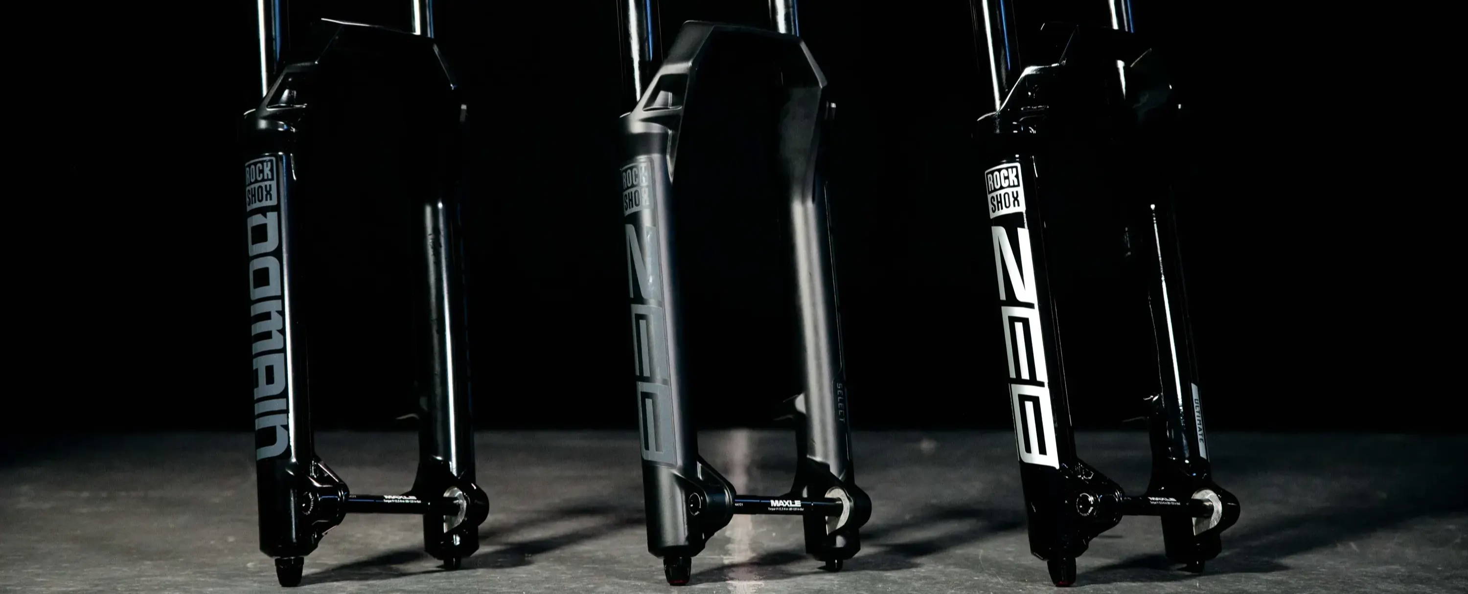 Rockshox domain zeb select and zeb ultimate on a shiny table with a black background