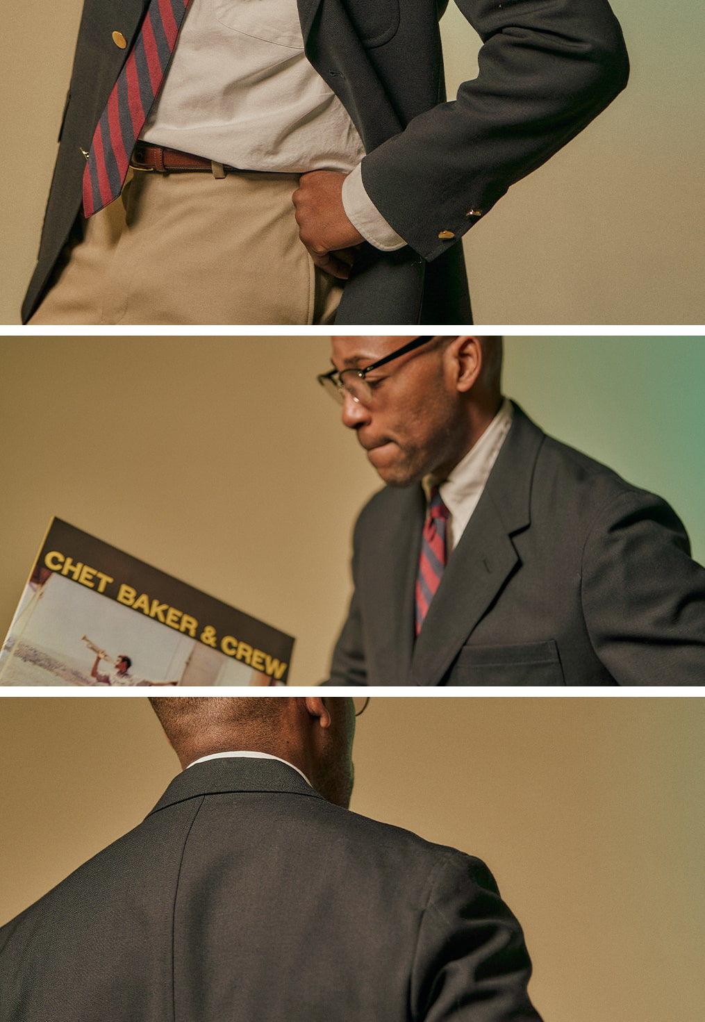 A man in a suit holding a record, with a neutral background.