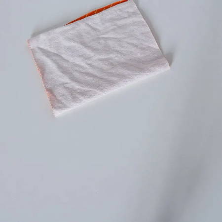Folded rectangular orange fabric piece to make a pumpkin