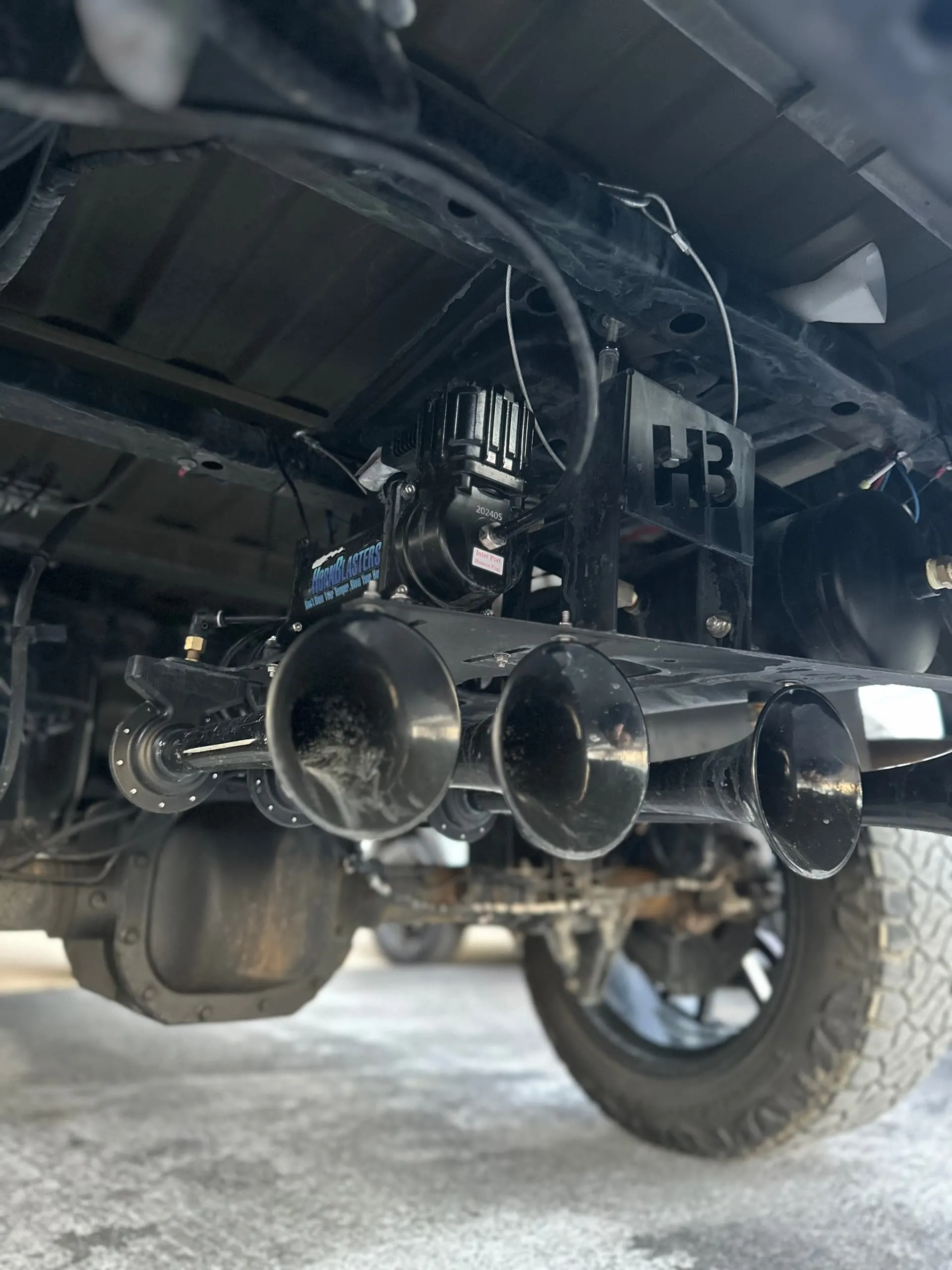 HornBlasters train horn kit with compressor and three black trumpets mounted under Tanner's Ford F-150