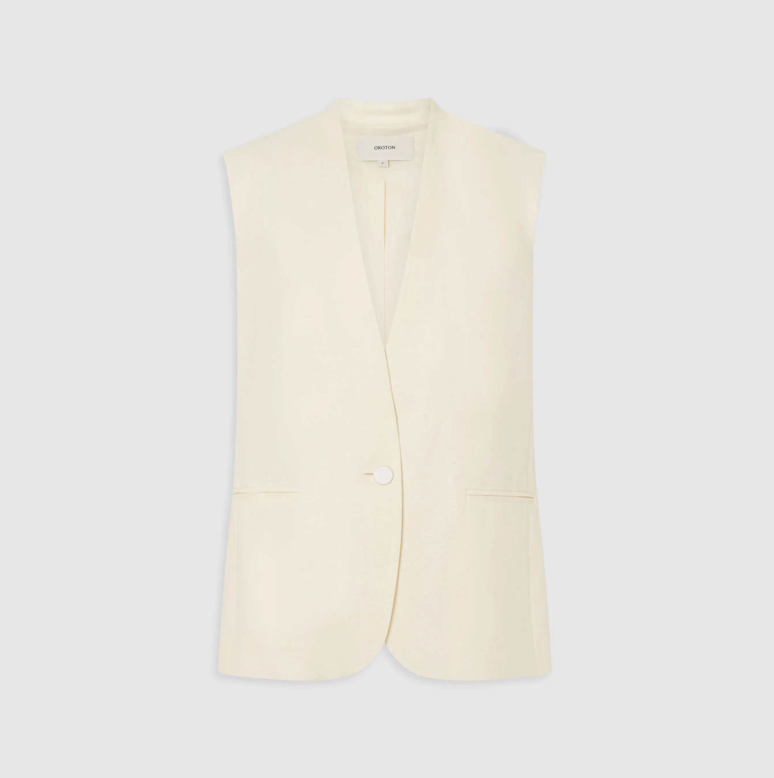 Cream sleeveless blazer with a single button and front pockets.