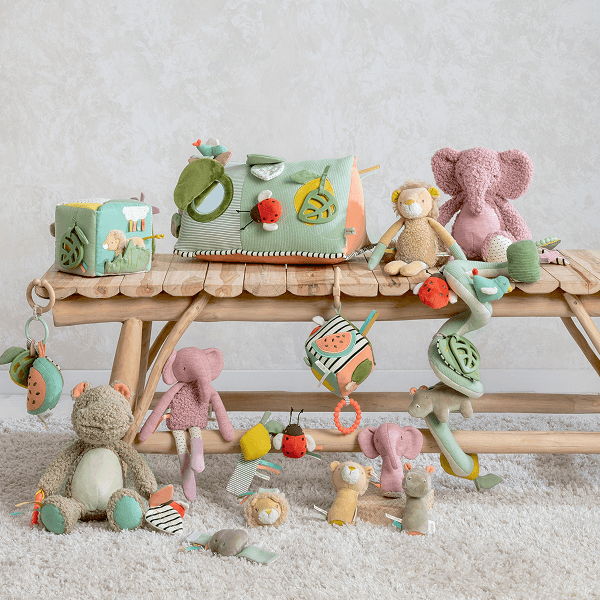 Colorful plush toys arranged on a wooden bench against a soft background.