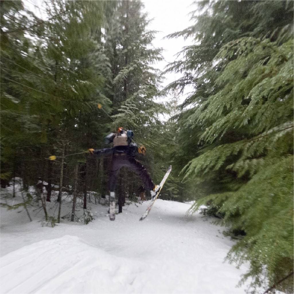 Man going off jump skiing in backcountry