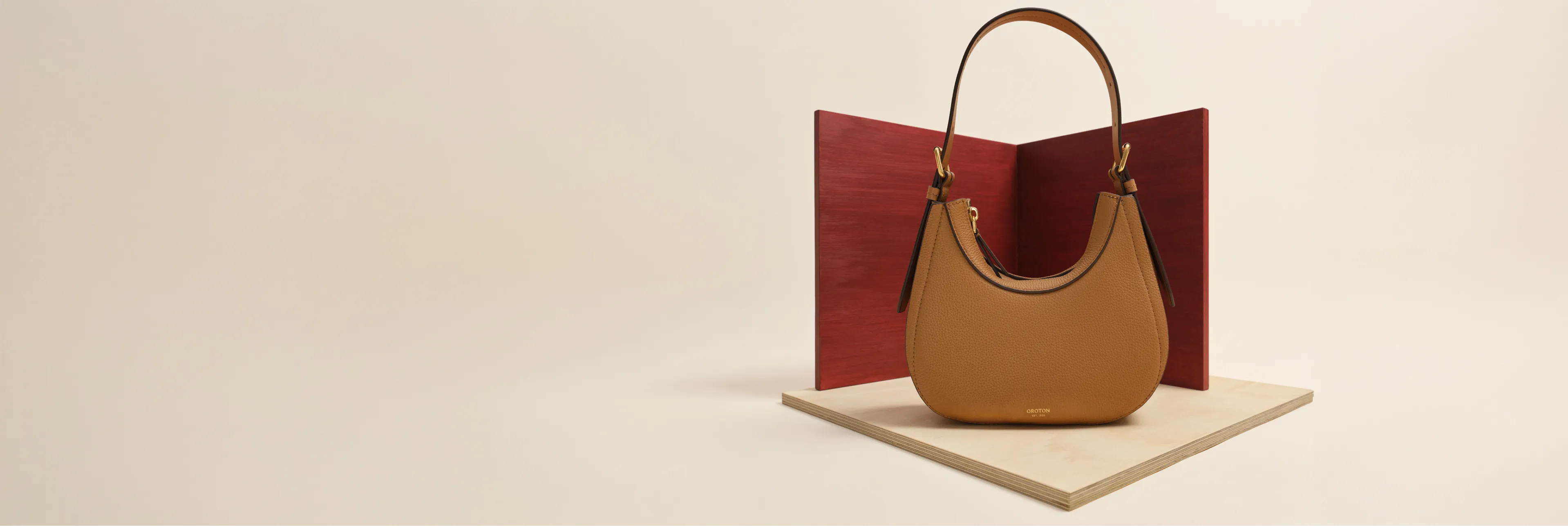 A stylish brown handbag displayed on a minimalist background.