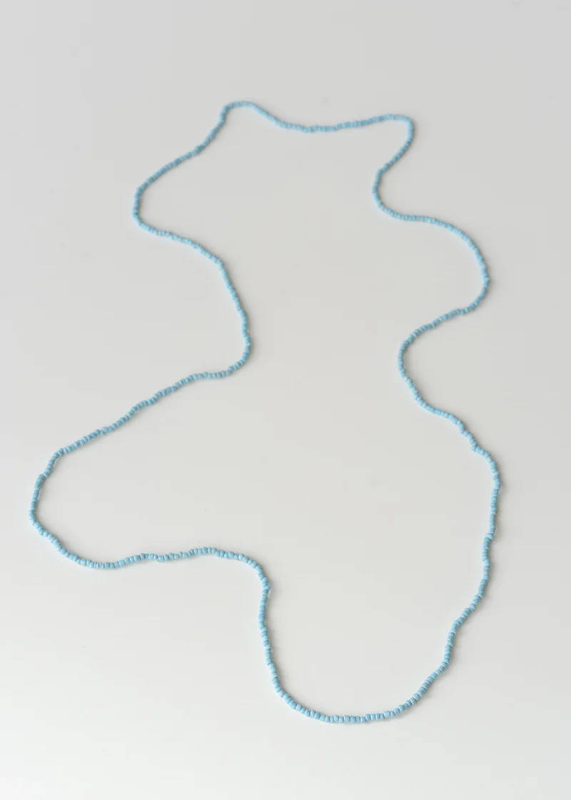 A pale blue small beaded necklace on a white background