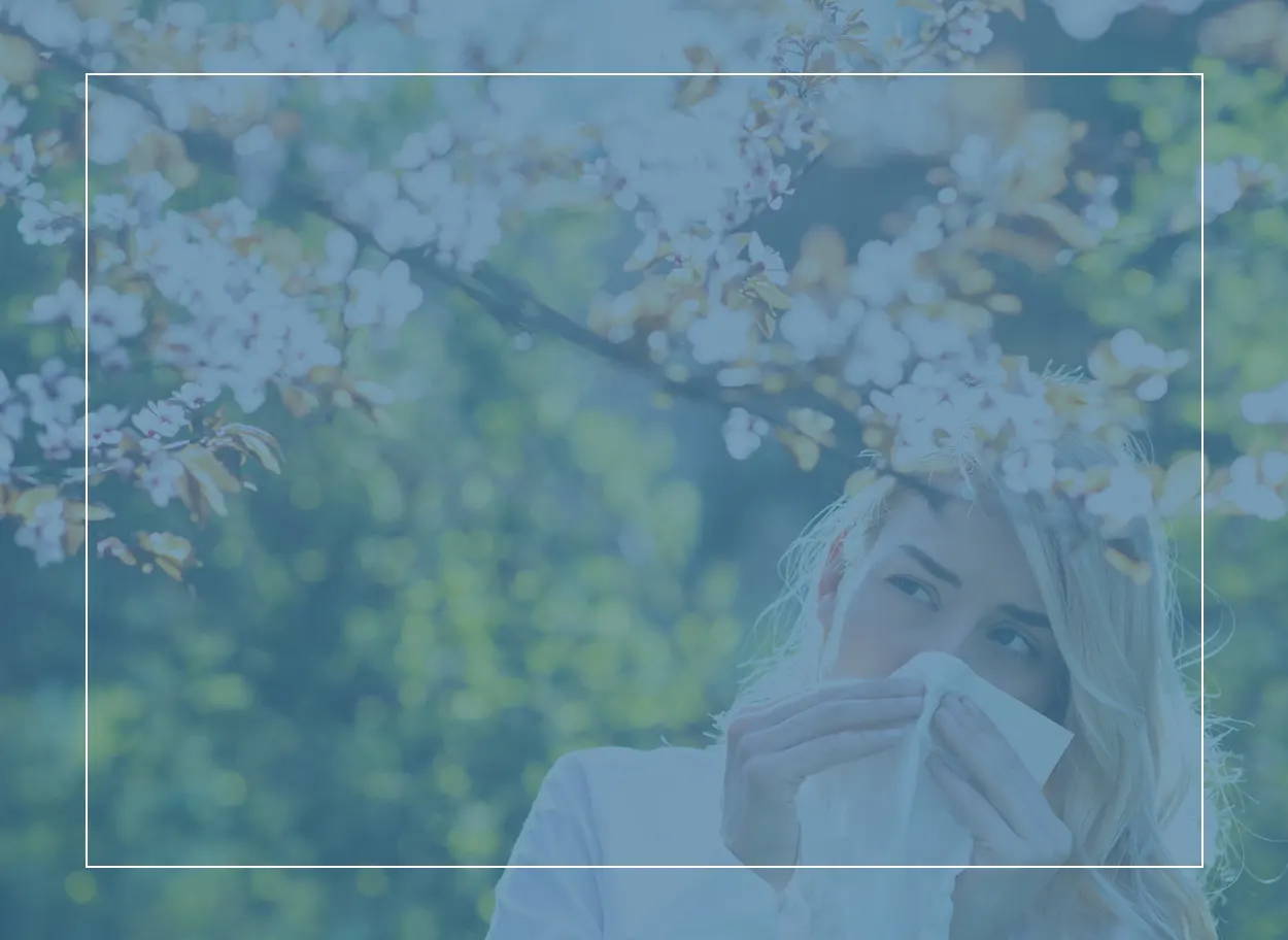 Frau mit einem Taschentuch an der Nase, draussen an einem Sommertag. Welche Pollen verursachen ihren Heuschnupfen? 