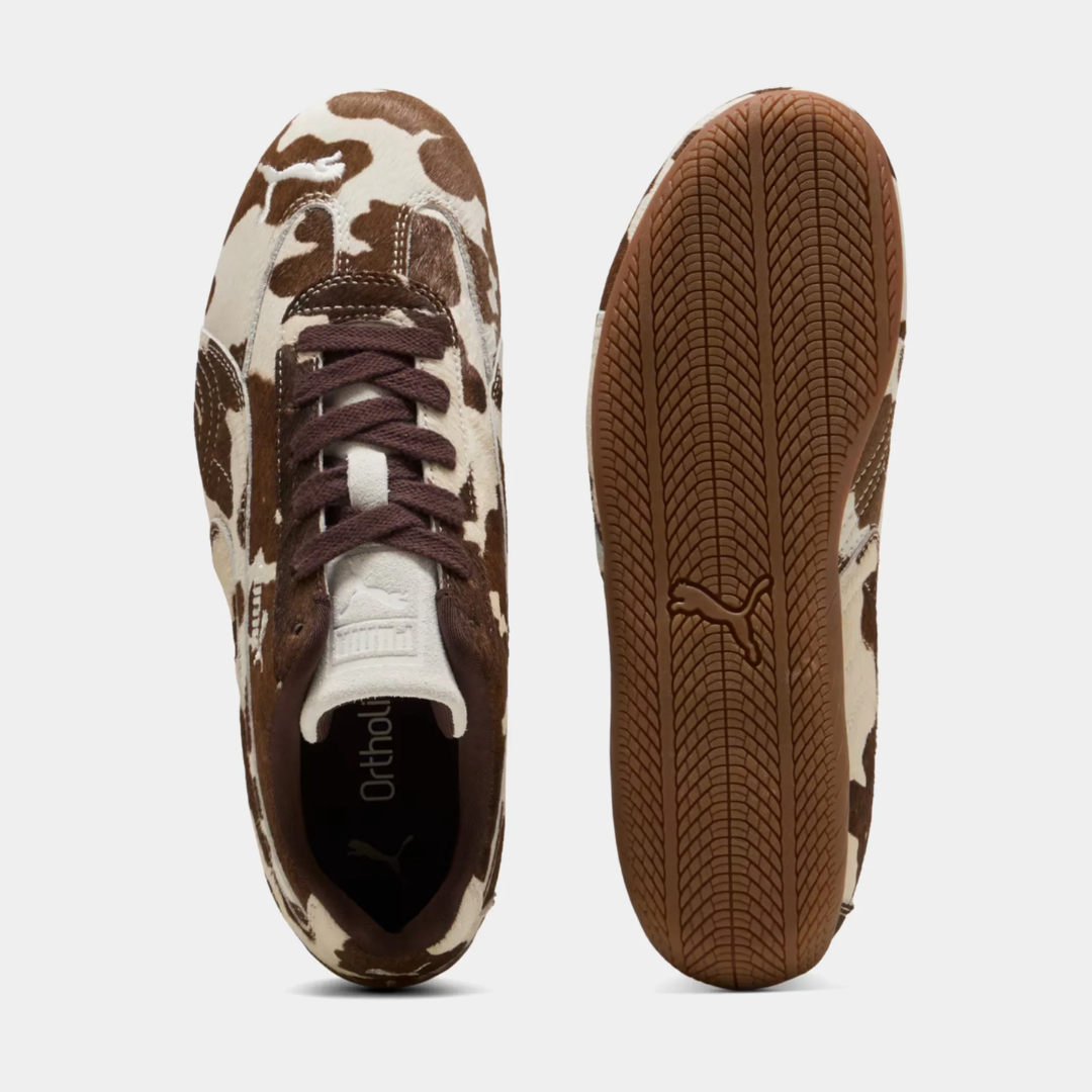 Brown and white cow-print sneakers on a neutral background.