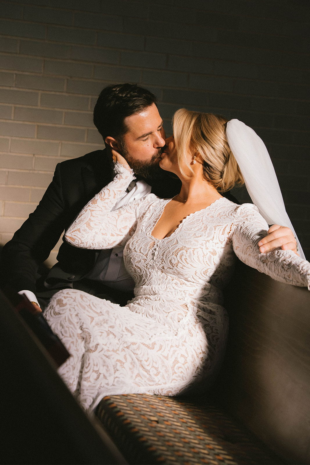 Couple sharing a romantic kiss in elegant attire.