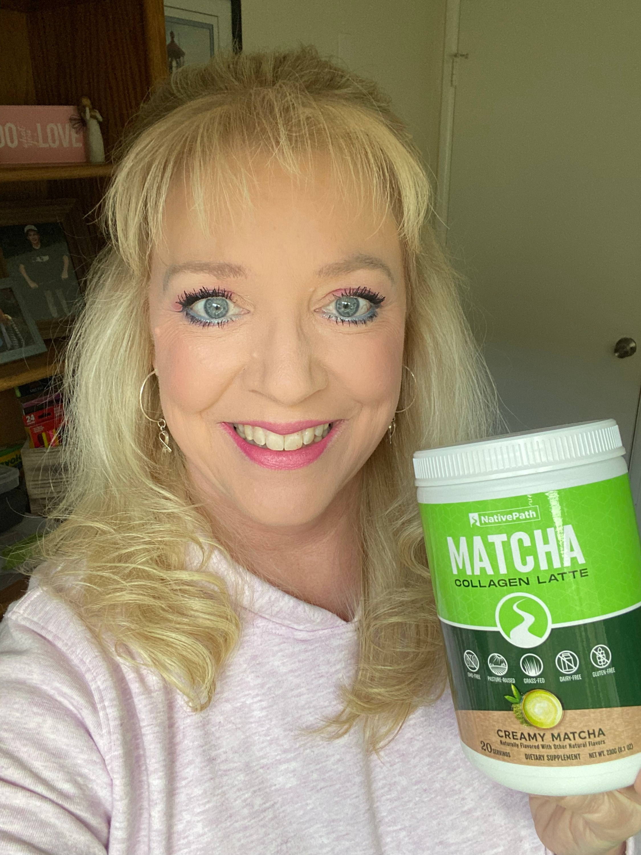NativePath female customer with blonde hair and blue eyes holding a jar of NativePath Matcha Latte