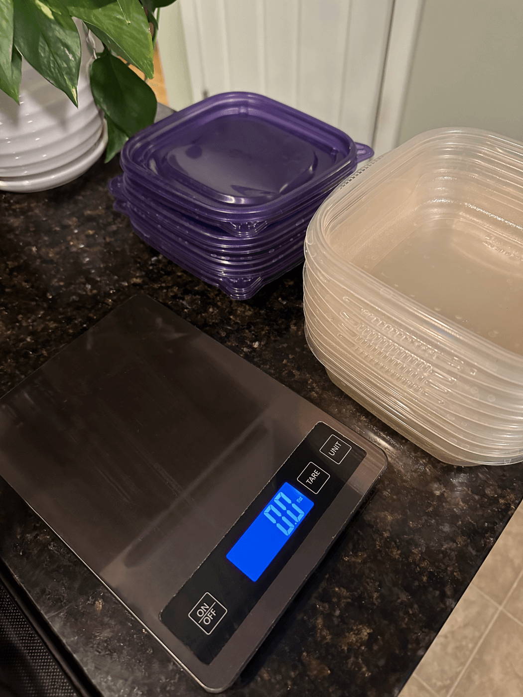 Scale on kitchen counter next to Tupperware containers and lids.