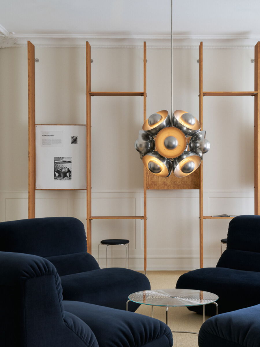 Modern living room with blue chairs and unique pendant light fixture.