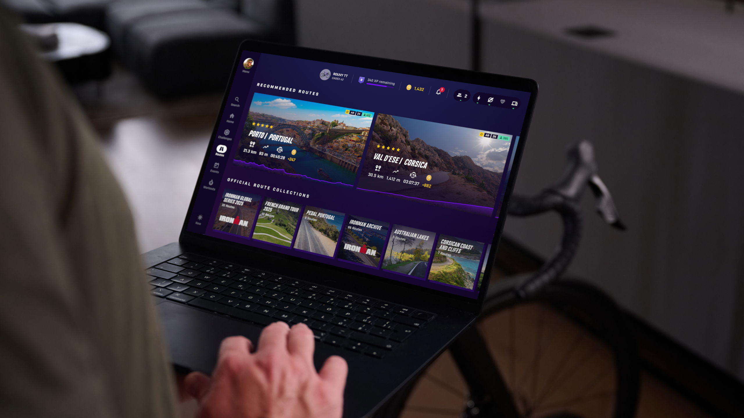 Person nutzt einen Laptop und wählt in der ROUVY-App verschiedene virtuelle Radstrecken und Trainingsrouten aus.