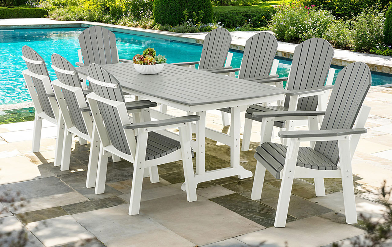 Outdoor dining set by a pool with gray and white chairs.