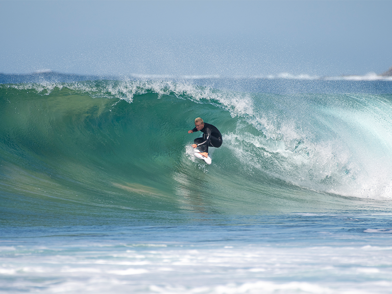 Surfer riding a large wave in the ocean.