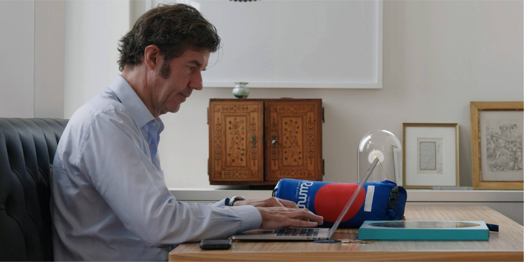 Stefan Sagmeister sitting at his computer with a Rumpl blanket