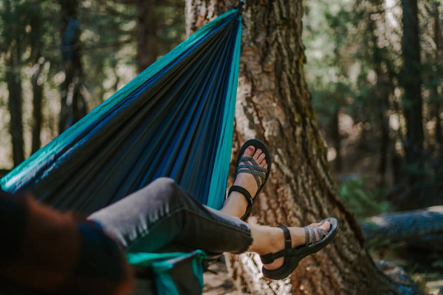 woman lying in hammock wearing  sandals