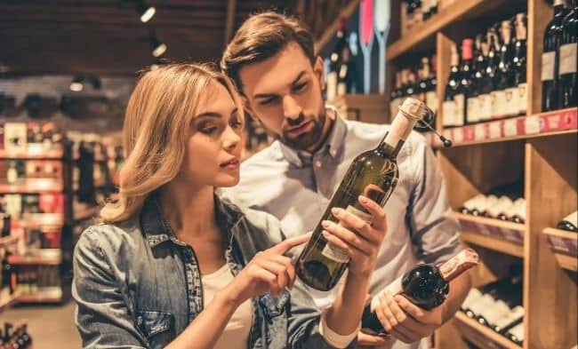 Couple reading a wine bottle