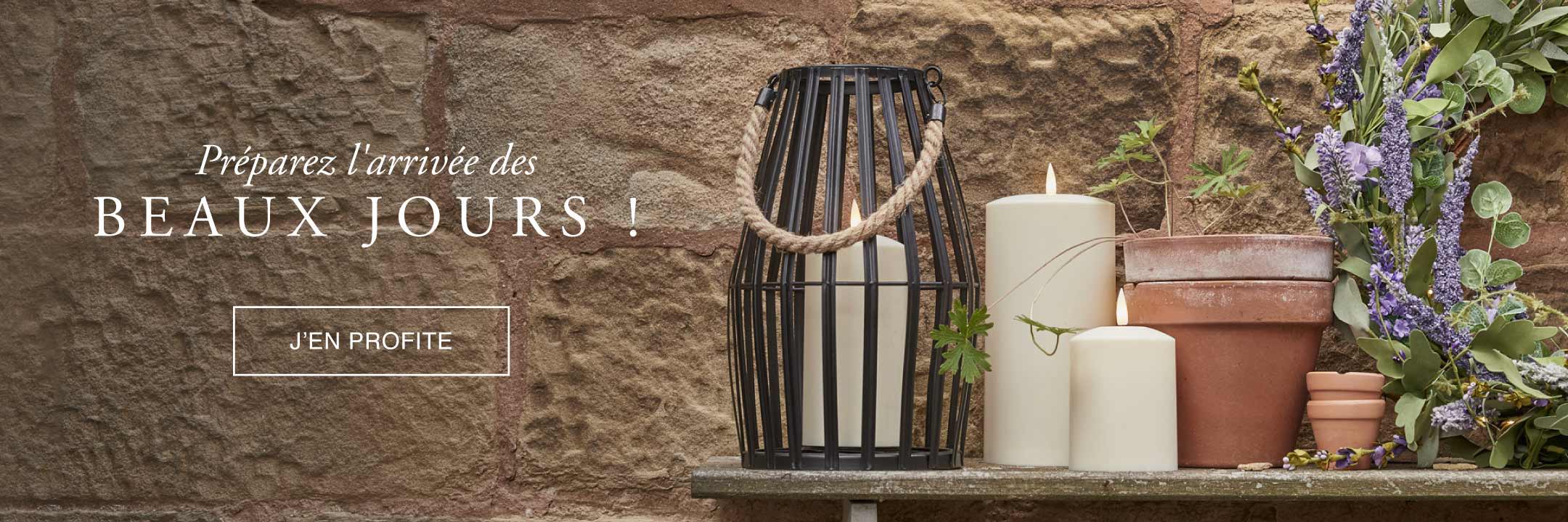 Lanterne d'extérieur avec des bougies d'extérieur et une couronne de fleur printanière posées dans le jardin. 