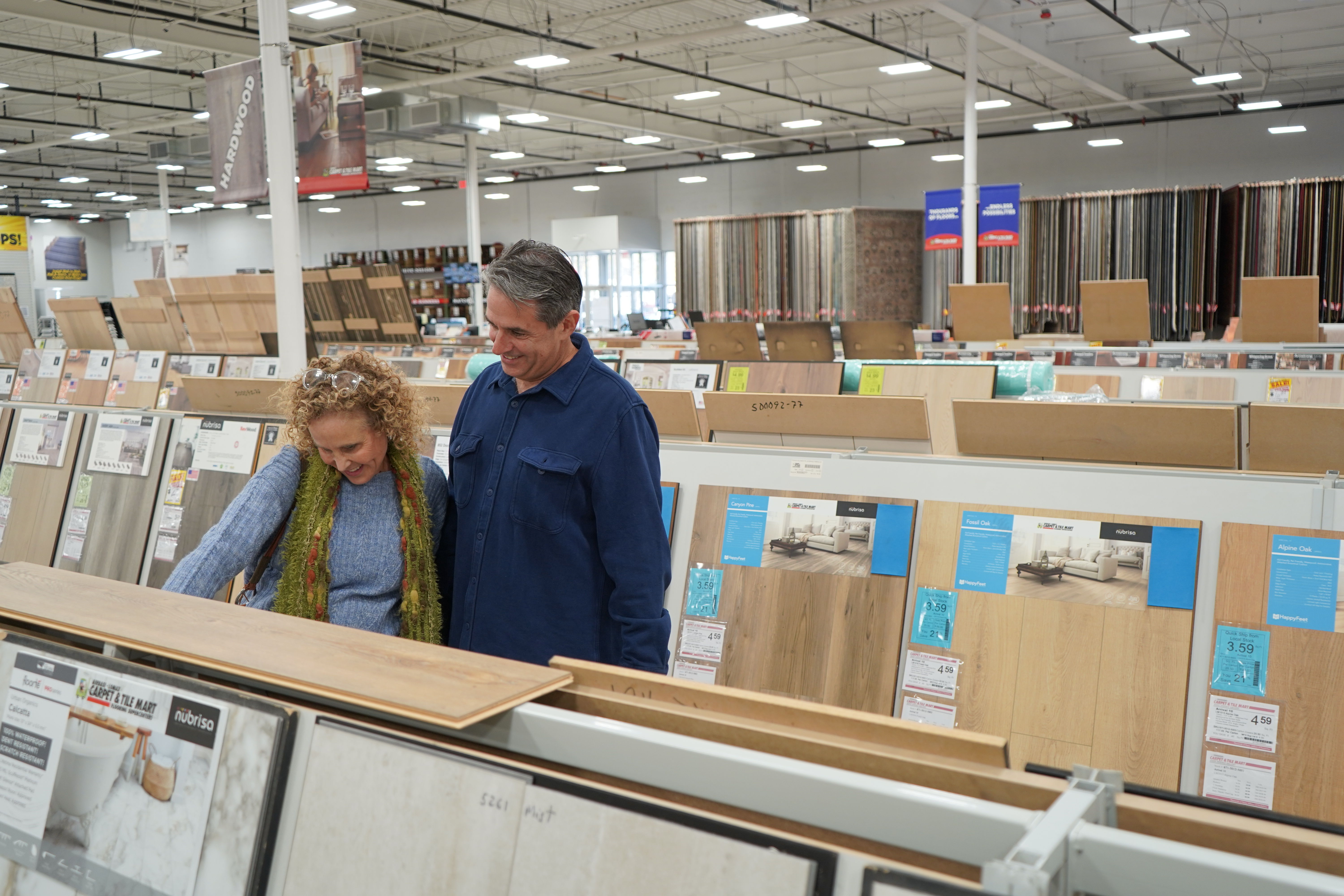 couple looking at hard surface flooring options in store