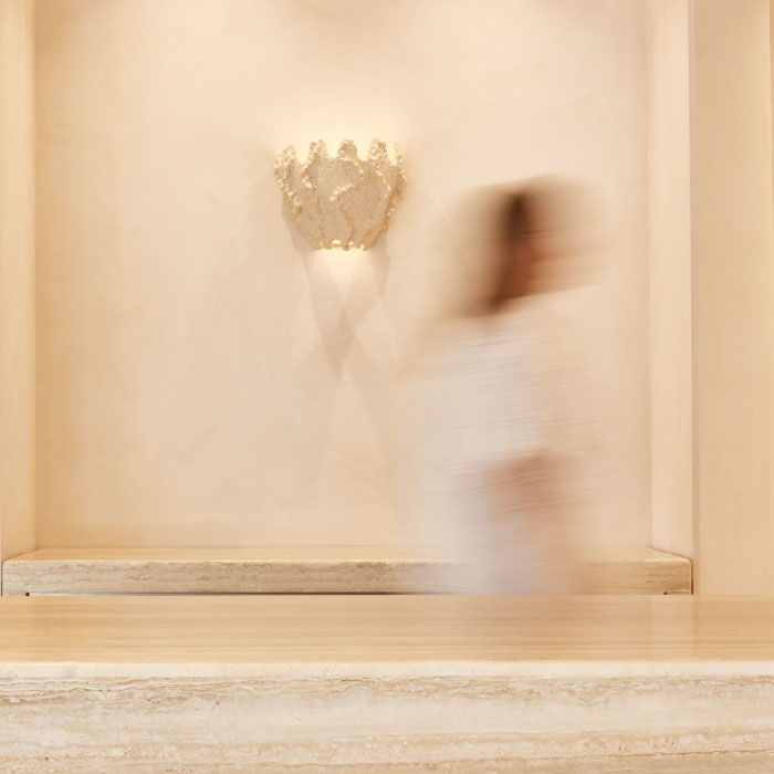 Woman walking in store with shell on wall