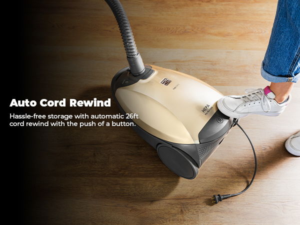 Vacuum cleaner with auto cord rewind feature on wooden floor.