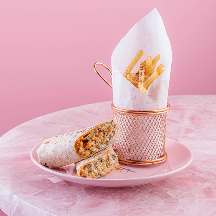 Chicken schawarma wrap with skinny fries on pink background