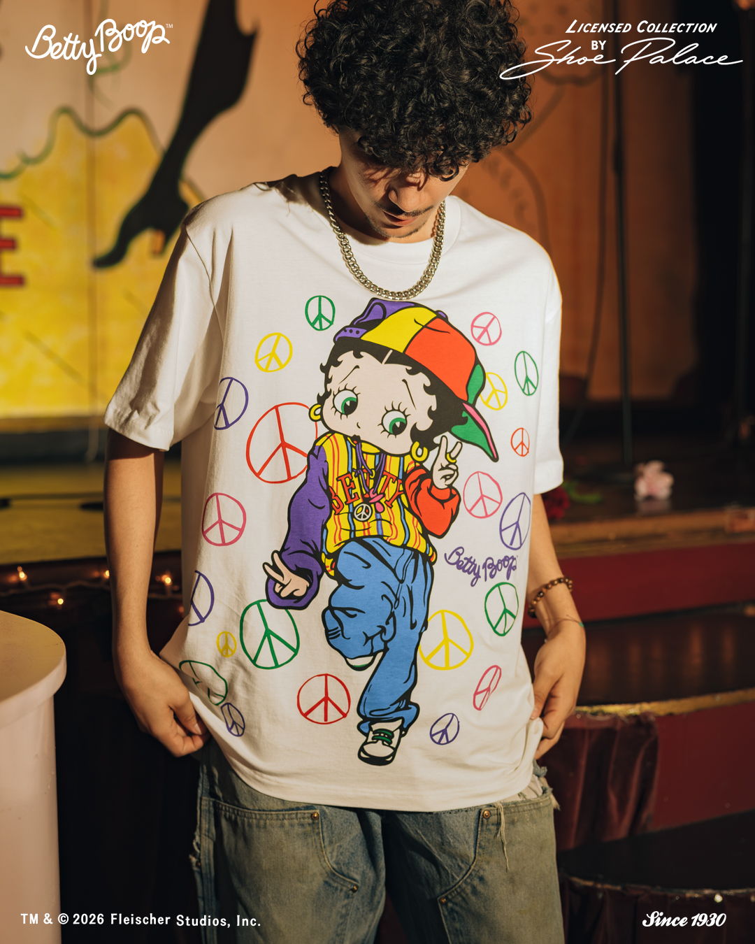 Person wearing a colorful Betty Boop graphic t-shirt with peace signs.
