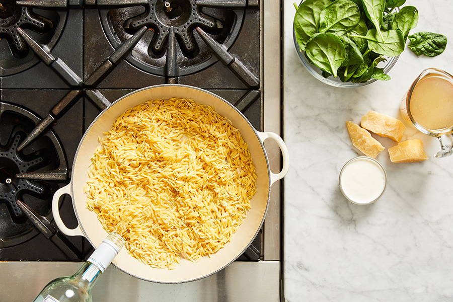 White wine added to pan with orzo