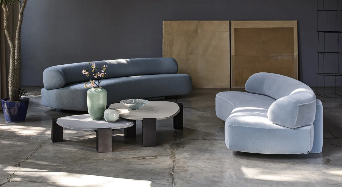 Modern living room with curved blue Moroso sofas and circular tables.