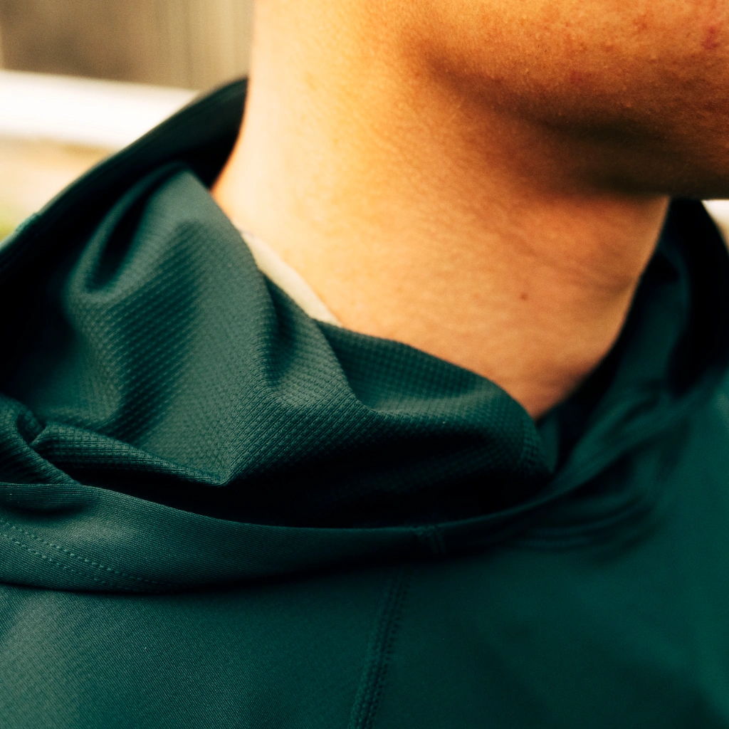 Close-up of a person's neck wearing a green garment.