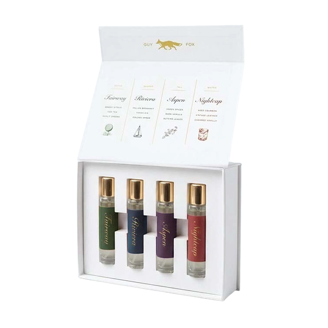 Four perfume bottles in a decorative box with labels.