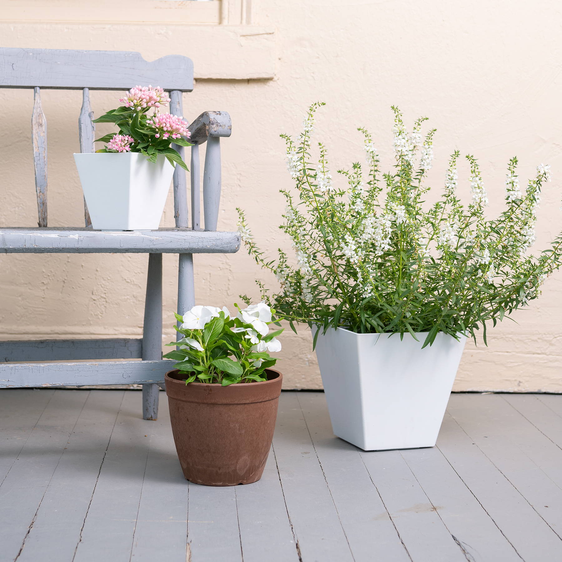 White and rust colored Artstone self-watering planters