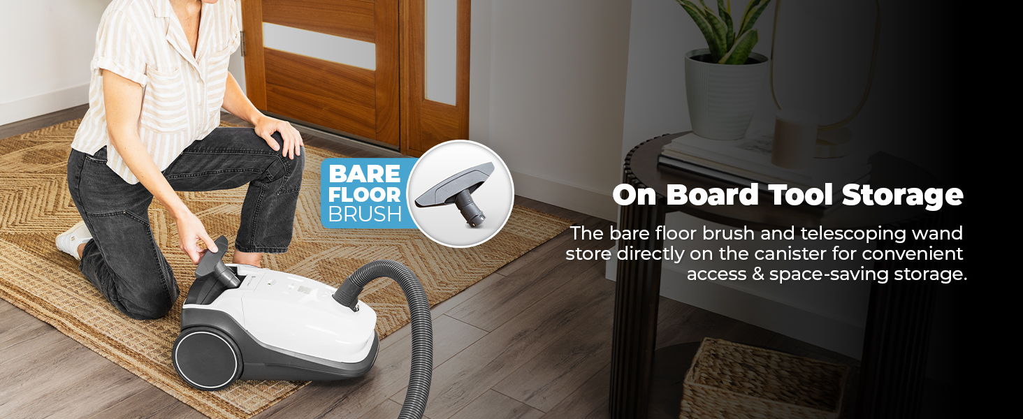 Person vacuuming a floor with an upright vacuum cleaner. On-board tool storage highlighted.