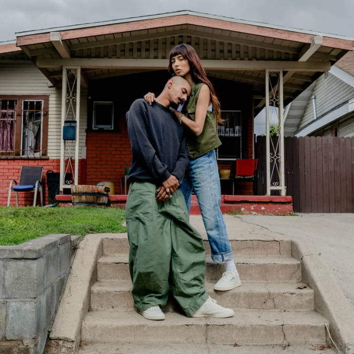 male and female model wearing reebok sneakers in front of hosue