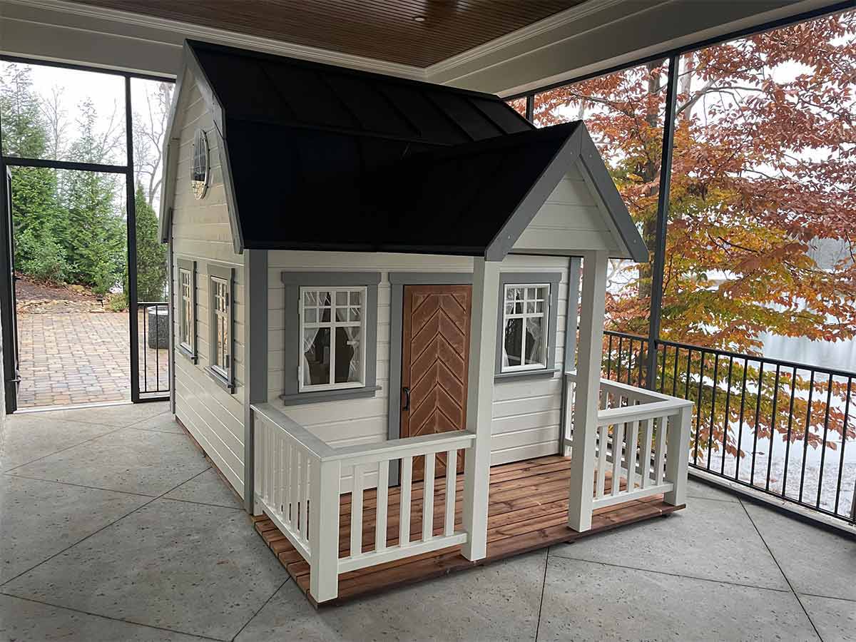 Farmhouse style Playhouse with top round window, loft and porch by WholeWoodPlayhouses