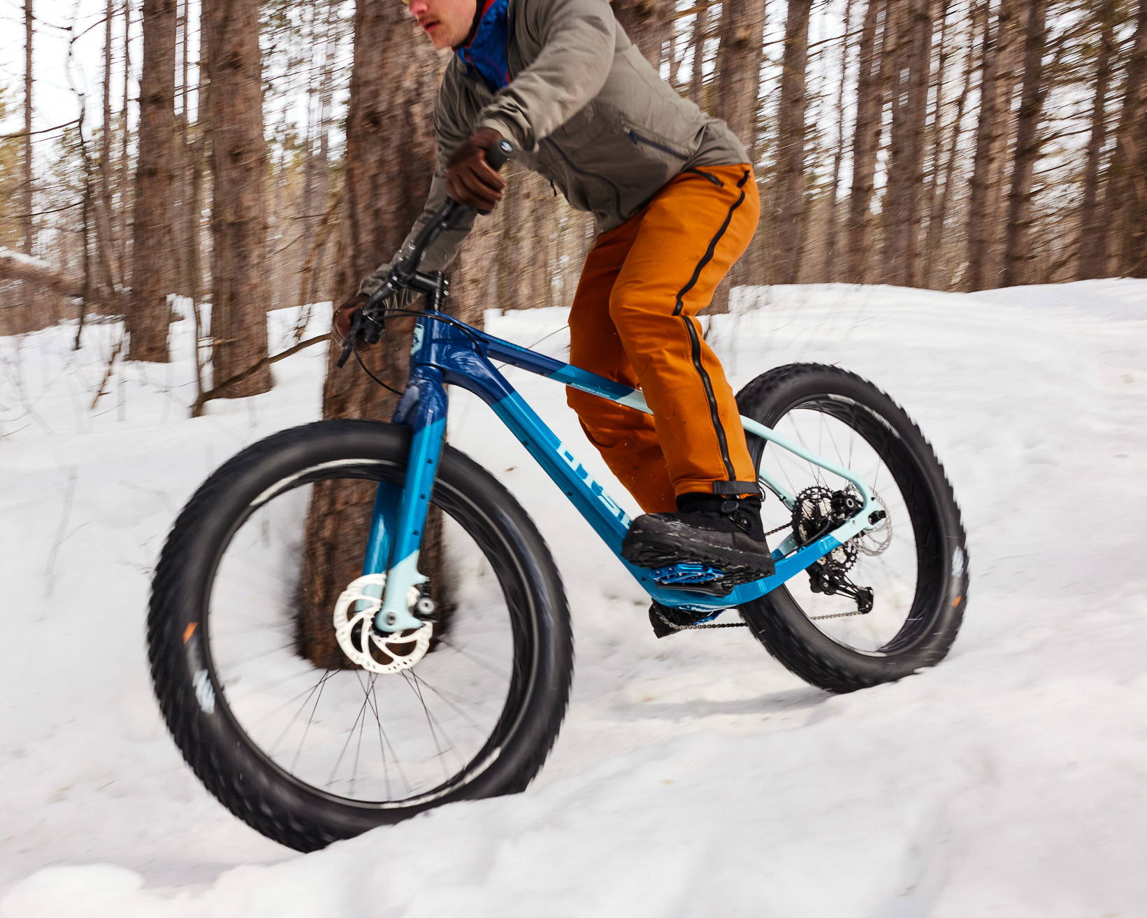 Blue Otso Voytek 2 fat bike being ridden on snow in the woods.