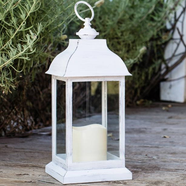 White lantern and candle duo in an outdoor garden setting