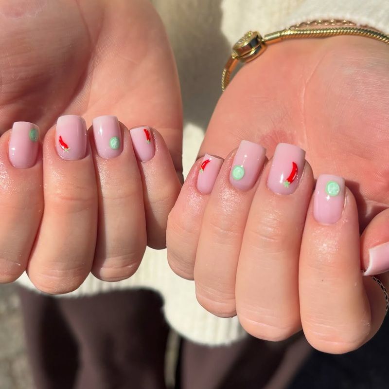 Two hands showing manicured nails with pastel colors and designs.