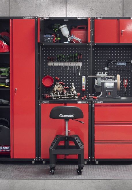 Red garage storage unit with tools, workbench, and a black rolling stool.
