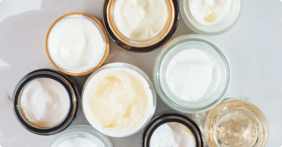 Various jars of skincare creams arranged on a surface.
