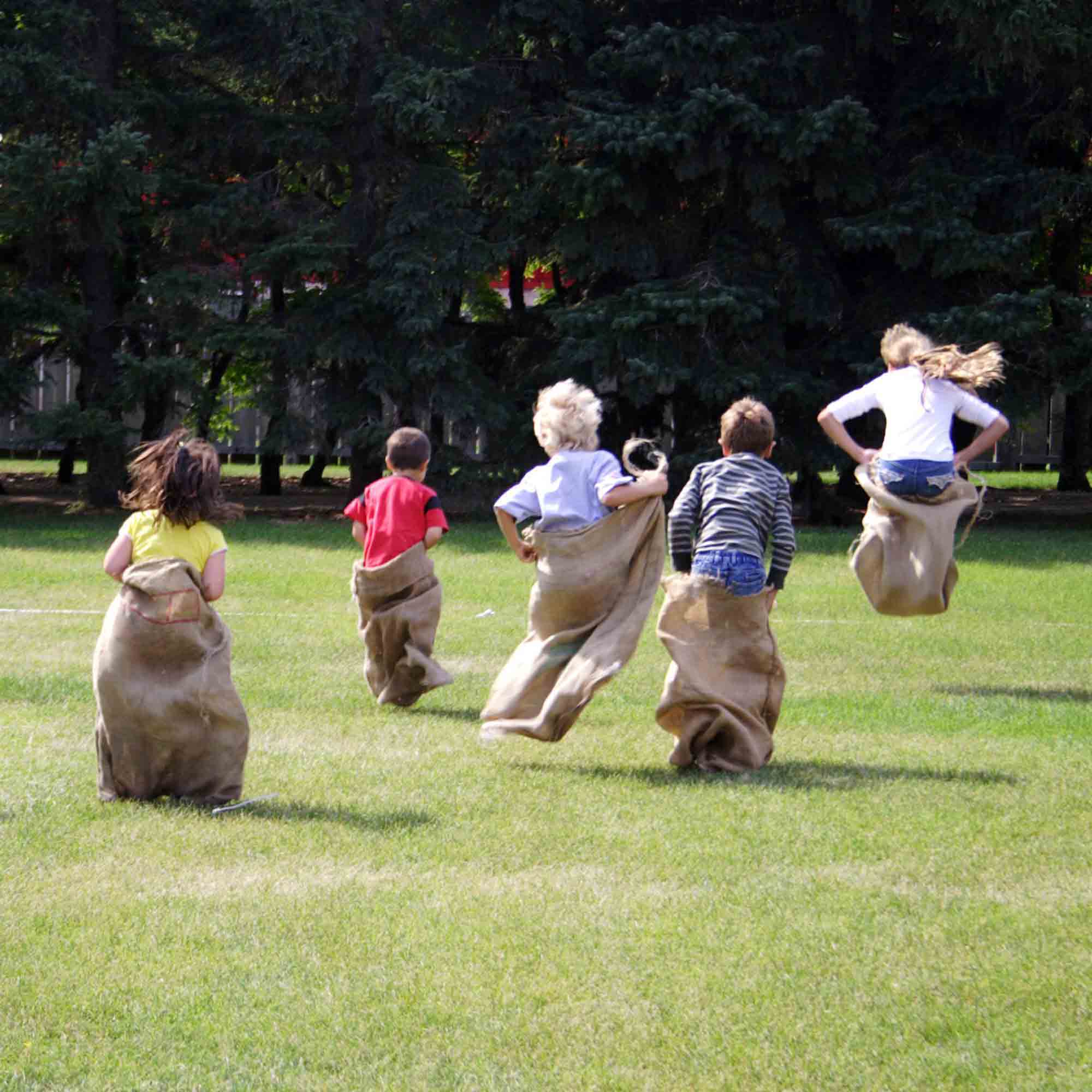 Children hopping inside sacks to complete sack race relay
